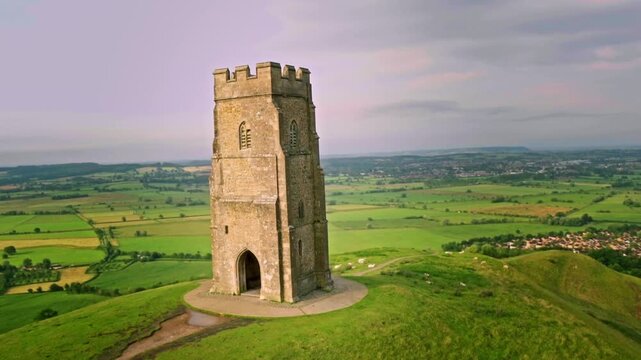 Ascending aerial view of the iconic Glastonbury Tor revealing the surrounding English landscape
