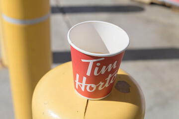 Obraz premium discarded Tim Hortons beverage cup on a safety barrier post, Toronto