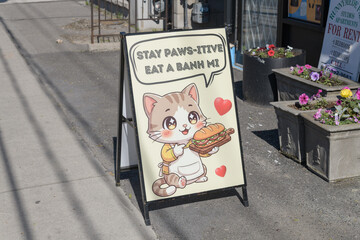 Naklejka premium cute a-frame sidewalk sign outside Banh Mi Happy, a sandwich shop, located at 2391 St Clair Av W, Toronto