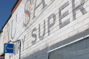 Naklejka premium old phone sign and retro painted wall sign outside S&A Variety Store, a convenience store, located at 128 Pritchard Av, northeast corner of Jane St, Toronto