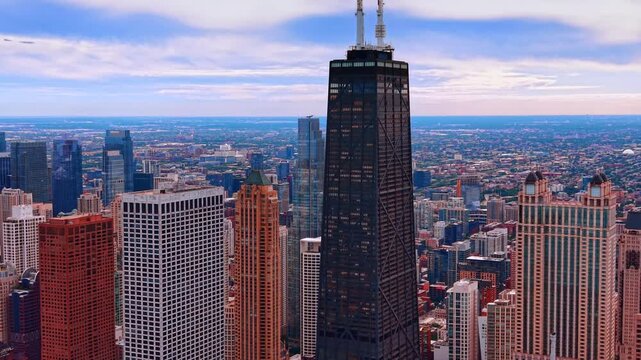 Moving near the top of the distinct, dark-colored skyscraper with twin antennas, formerly known as the John Hancock Center. Famous skyscrapers of Chicago downtown.