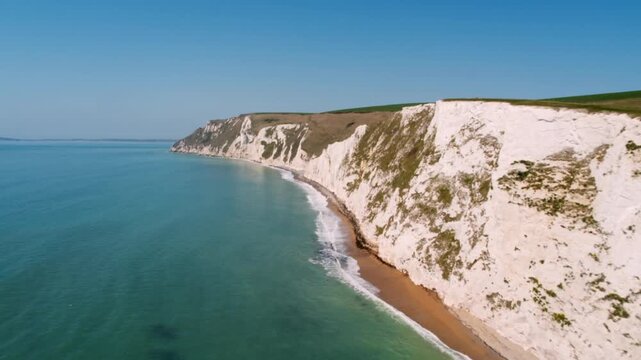 Dramatic aerial view flying alongside the stunning white cliffs on a sunny day in England
