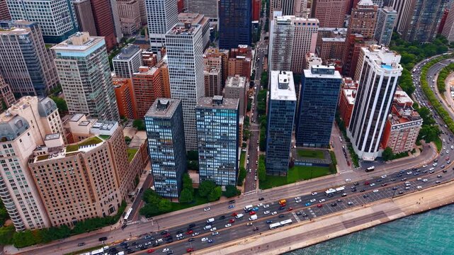Famous Lake Shore Drive with hectic traffic. Drone footage descending over the waterscape of Lake Michigan in Chicago, Illinois, USA.