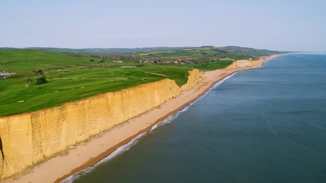 Drone footage flying along the stunning coastline of West Bay, Dorset, with its iconic golden cliffs