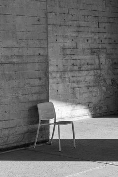 Single Modern Chair Against Concrete Wall in Black and White