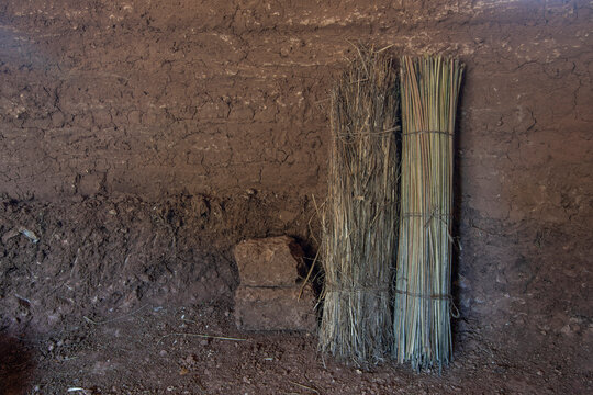 Interior of earthen hut with primitive rolled mats