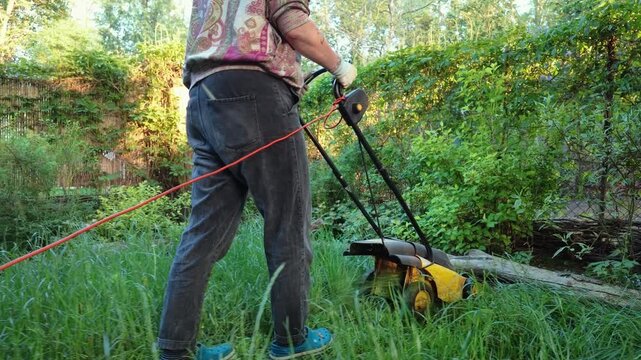 Woman Mowing Grass with Electric Lawn Mower
