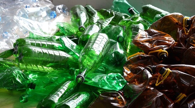 Crushed PET bottles sorted according to color: blue, transparent, brown and green