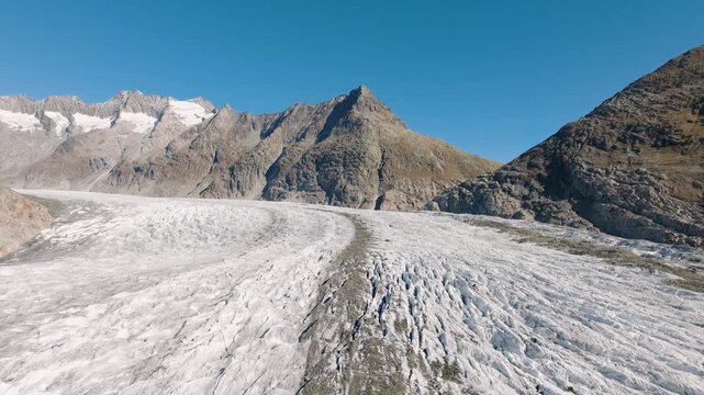 Aerial drone view of Aletsch Glacier in Switzerland. Frozen ice texture, crevasses, and alpine nature landscape from above. Melting glaciers. Global warming.