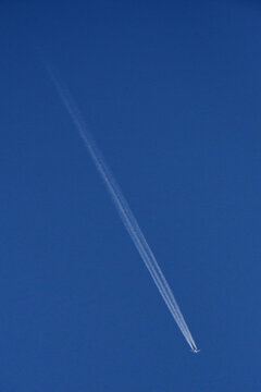 A two-engine jet with  three contrails. A drop in air pressure behind the fuselage and wings creates a third, invisible band of water vapor that condenses into a icy contrail 