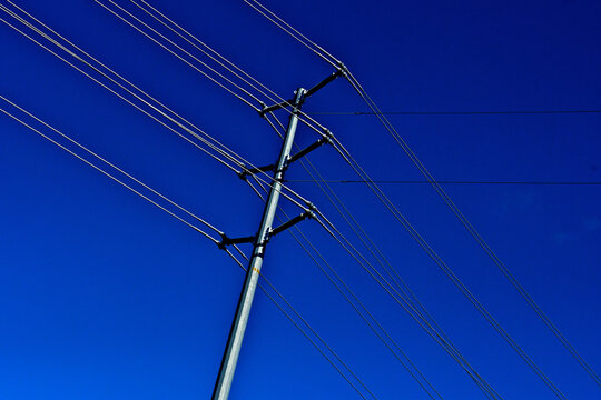 Dual cables on high-voltage transmission towers are used to reduce corona discharge and manage electrical field intensity.