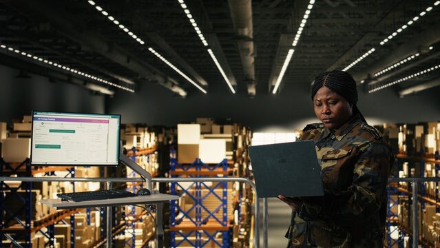 Female military personnel overseeing mission logistics for e-commerce operations in distribution hub, cargo transportation and shipment tracking, Soldier in uniform manages supply chain process.