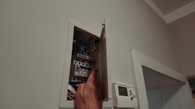 Senior Man Checking Electrical Fuse Box at Home
