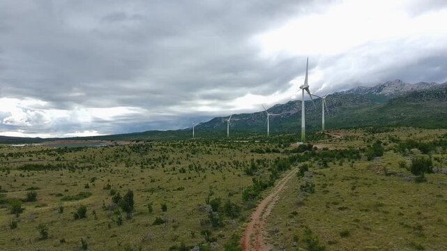 Drone video of Wind Turbines Turning on a Mountain with a Sky Background. Concept of Environmental Conservation, Wind farm