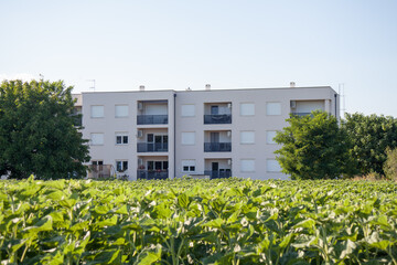 Modern Apartment Building Facing Green Agricultural Field © Embreuš Marko