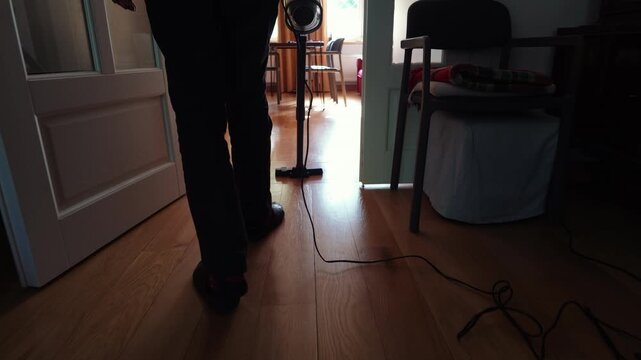 Senior Man Vacuuming Floor at Home
 