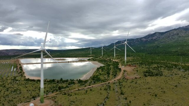 Drone video of Wind Turbines Turning on a Mountain with a Sky Background. Concept of Environmental Conservation, Wind farm