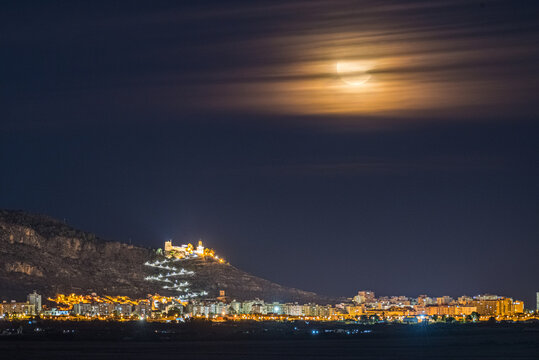 Scenic Night View of the Moon Above Cullera Medieval Castle in Spain