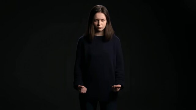 Woman in dark room shows confidence as she gradually moves from relaxed to assertive stance
