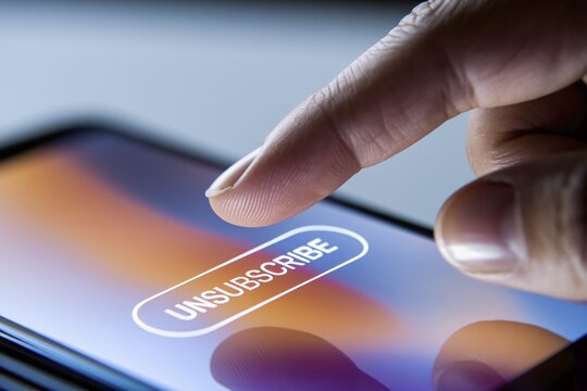 Close up of person's finger hovering over unsubscribe button on mobile phone screen. Generative Ai, AI generated