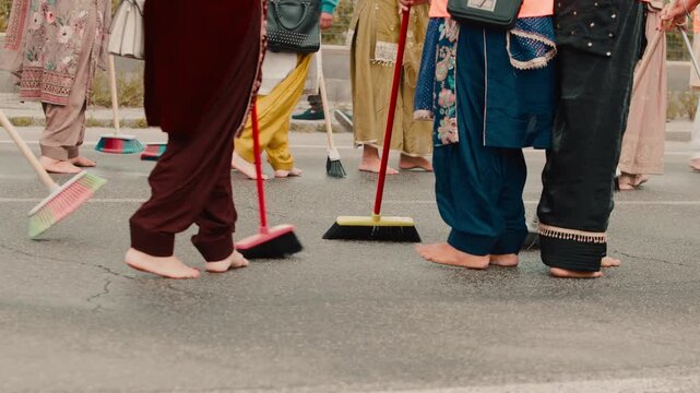 Women crowd sweep the streets with brooms during the Vaisakhi parade in India