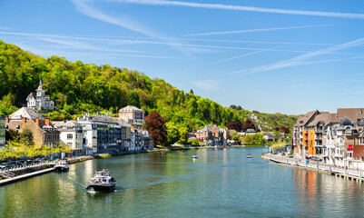 Obraz premium Beautiful view of the Meuse River with boats and historic buildings in Dinant, Belgium.