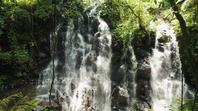 Tourists climbing Kanto Lampo waterfall in Bali