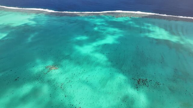 Aerial turquoise lagoon coastline in New Caledonia showcasing coral reef patches, shallow turquoise waters, the longest barrier reef in the world New Caledonia.