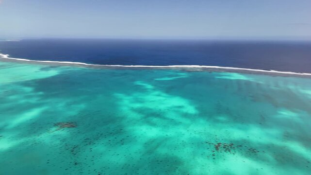 Aerial turquoise lagoon coastline in New Caledonia showcasing coral reef patches, shallow turquoise waters, the longest barrier reef in the world New Caledonia.