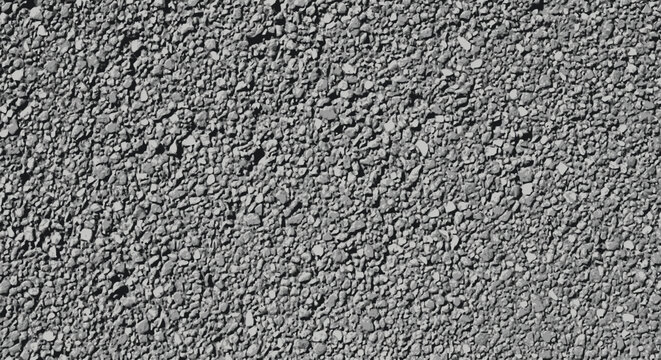 Close-up texture of dark grey asphalt surface with small pebbles, ideal for backgrounds and construction themes