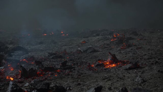 Panning shot across a desolate planetary wasteland littered with smoking hot black meteorite rock fragments