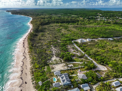 Aerial view of North Palmetto Point Beach with turquoise waters, white sand, and lush tropical vegetation in North Palmetto Point, Central Eleuthera, The Bahamas.