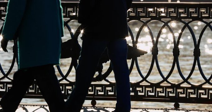 picturesque metal railings with a double-headed eagle and the crown of the Russian Empire on embankment in St. Petersburg, Russia, walking people, sunny autumn day, incredible sun glare Russia