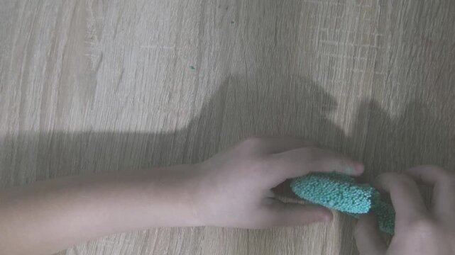 child's hands shaping soft foam clay, creativity and sensory play in early childhood development, fine motor skills, playful moment