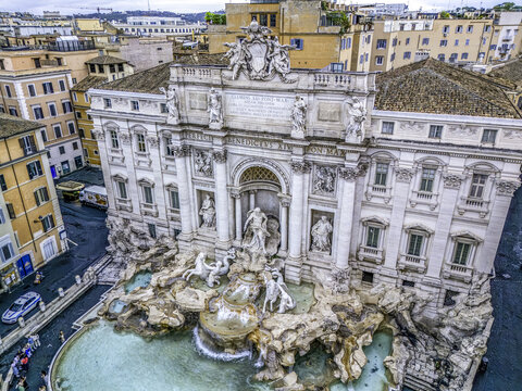 Roma, Italy - 20 May 2024: Aerial view of the Trevi Fountain featuring intricate Baroque sculptures and the turquoise water basin surrounded by historic buildings.