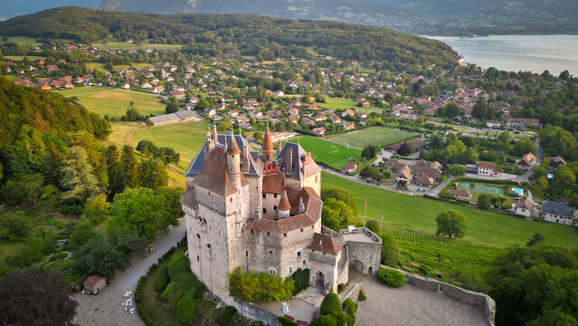 Menthon-Saint-Bernard, France - 09 July 2023: Aerial view of the historic Chateau de Menthon-Saint-Bernard with stone turrets overlooking Lake Annecy and the surrounding landscape.