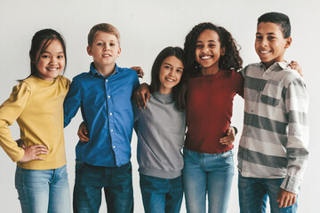 Obraz premium Smiling Group Of Multiracial Children, Three Females And Two Males, Posing Together With Joy At Studio Setting, Celebrating Friendship And Togetherness, Showcasing Diversity And Happiness