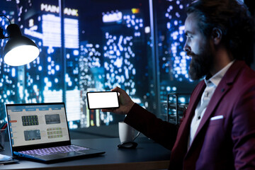 Fototapeta premium Chairman holding phone running white screen in the office, examining accounting work on online data program. Chief executive office using blank mockup layout on smartphone app.
