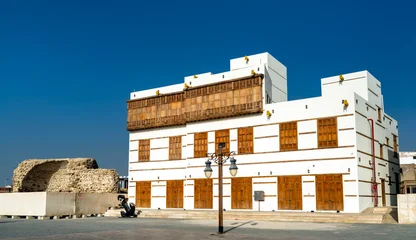 Beautifully restored white building with traditional wooden mashrabiya windows in the Yanbu Historic Area of Saudi Arabia. © Leonid Andronov
