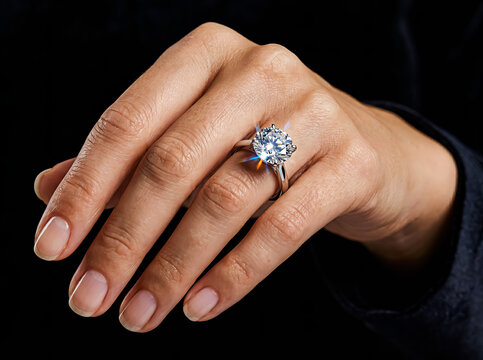Woman's Hand Wearing Sparkling Solitaire Diamond Ring