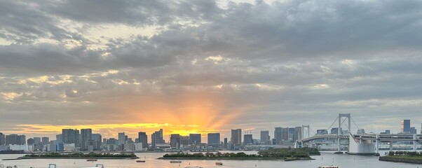 Fototapeta premium Tokyo Bay Sunset with Rainbow Bridge and City Skyline from Odaiba