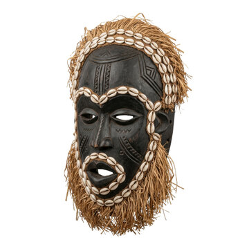 An authentic African tribal mask carved from dark wood, adorned with intricate patterns, cowrie shells around the face and headdress, and raffia trim. Isolated on a transparent background.