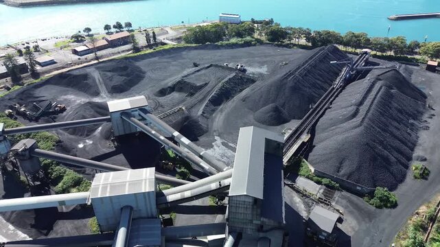 Aerial Drone Flyover of Coastal Coal Stockpiles and Conveyor Infrastructure at Industrial Harbour