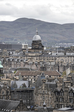 View of the historic Old College dome and stone rooftops with the Pentland Hills in the background in Edinburgh, Scotland, United Kingdom.