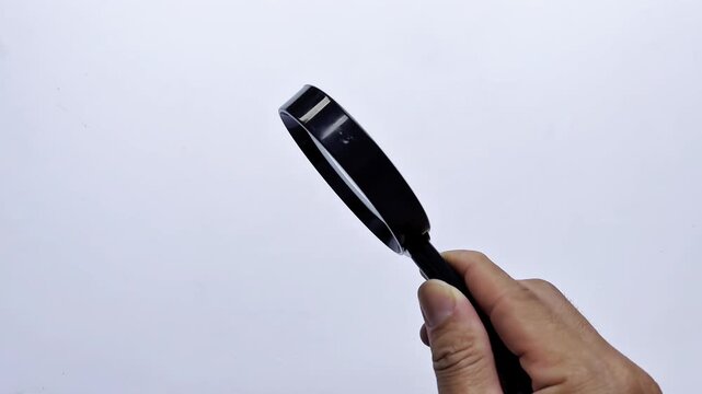 A magnifying glass is rotated and shaken on a white background. Search symbol. Research.  