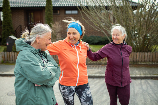 Senior women friends walking for fitness in suburban neighborhood