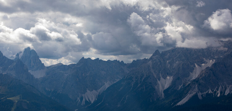 View of the jagged peaks of the Dolomites mountain range under a dramatic overcast sky with heavy grey clouds Rocca Pietore, Veneto, Italy.