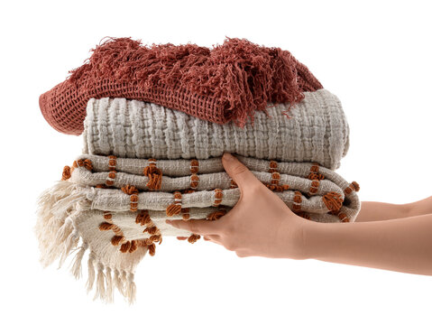 Female hands with stack of blankets isolated on white background