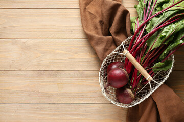 Basket with fresh beetroots on wooden background