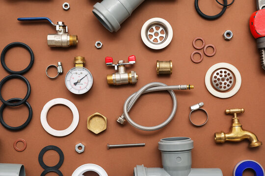 Set of plumber's items on brown background